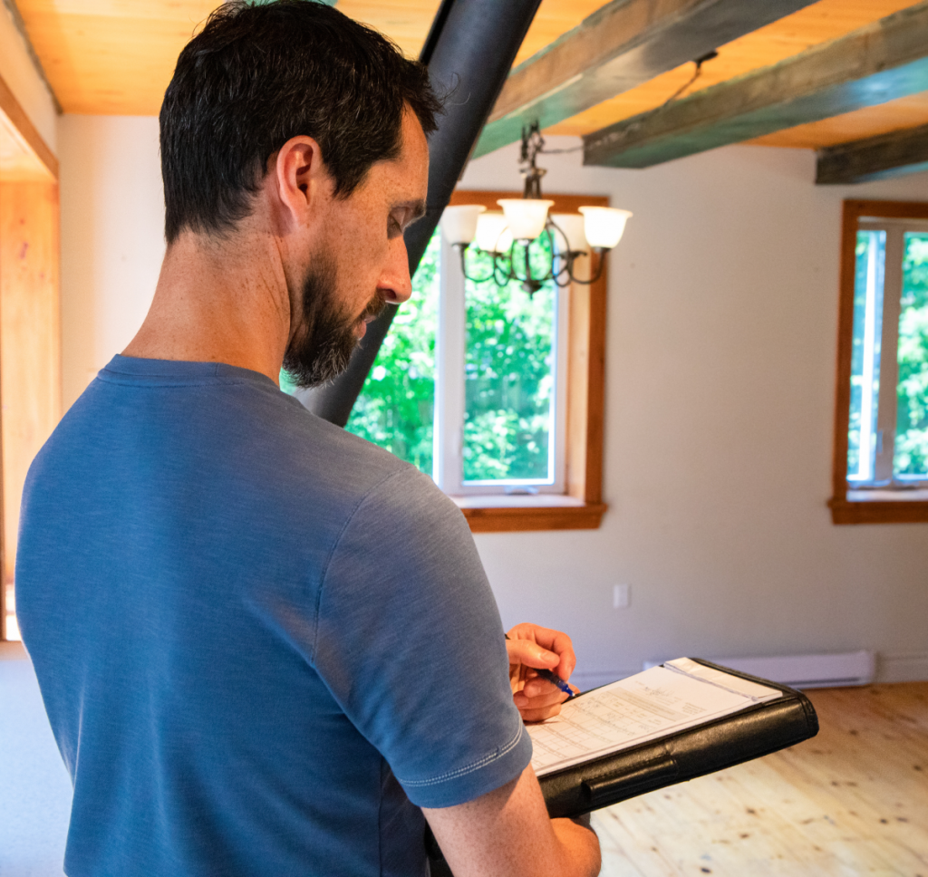 A man holding a clipboard while standing in a room.